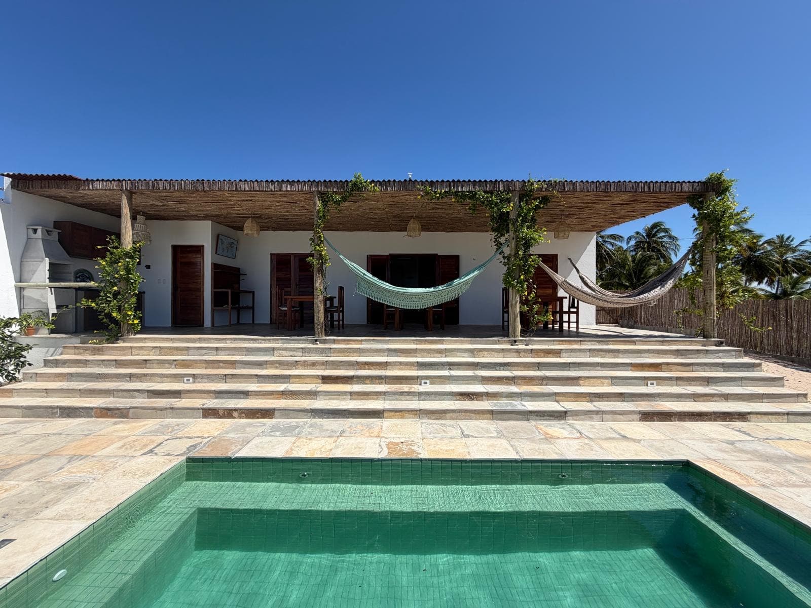 La maison, sa véranda et sa piscine en plein jour