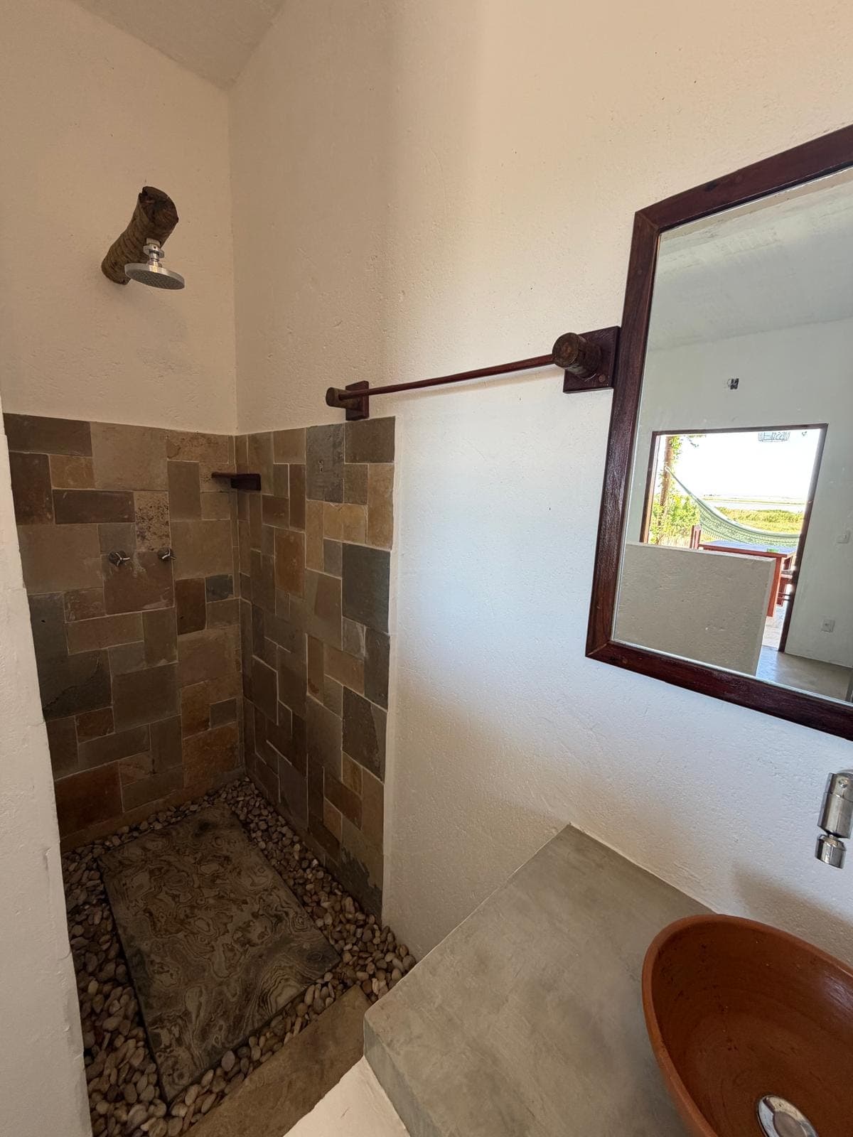 Salle d'eau : douche à l'italienne en pierre et vasque en terre cuite