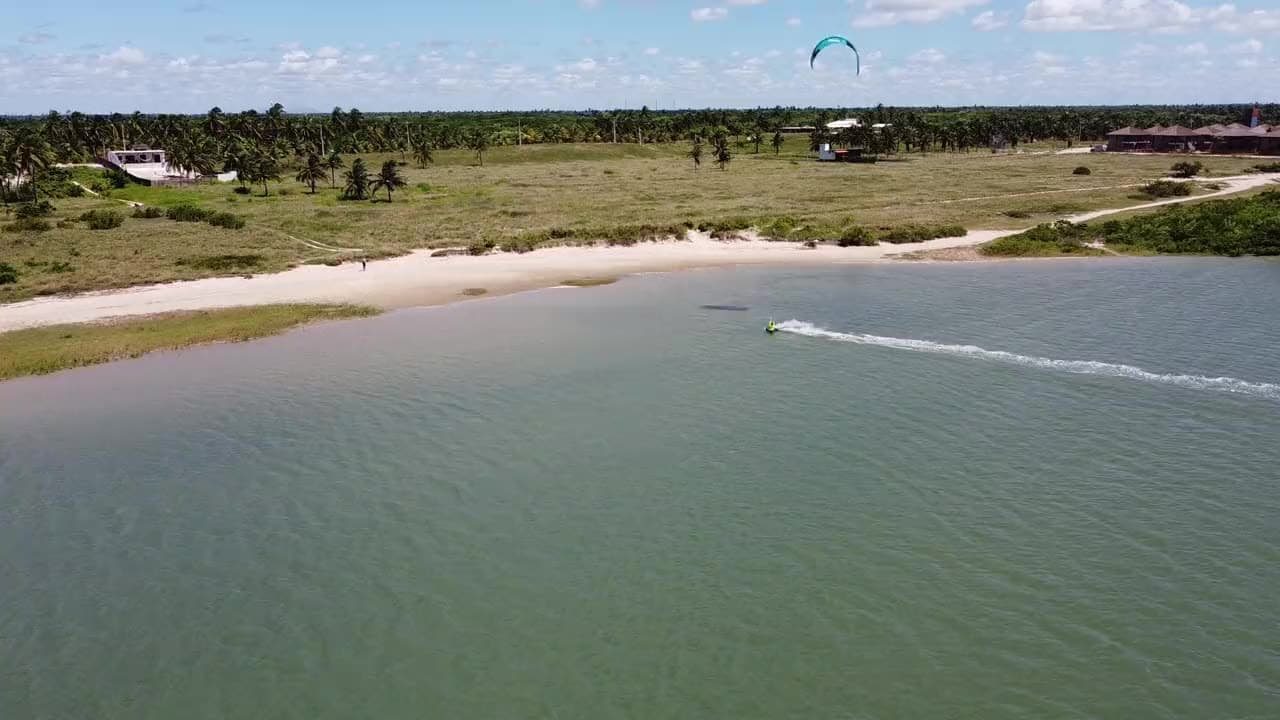 Vista aérea da lagoa de Ilha do Guajiru: um kitesurfista desliza sobre a água turquesa